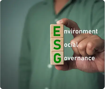 A hand holding three wooden blocks vertically stacked and labeled E (environment), S (social), and G (governance), symbolizing ESG assessment and responsible investment.